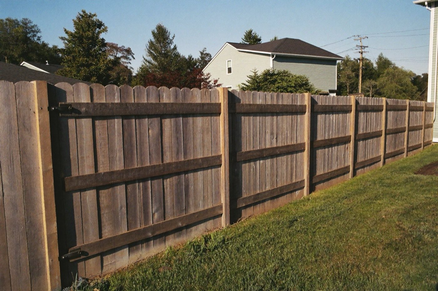 Finished six-foot cedar privacy fence along a backyard property line — wood fence installation cost per linear foot