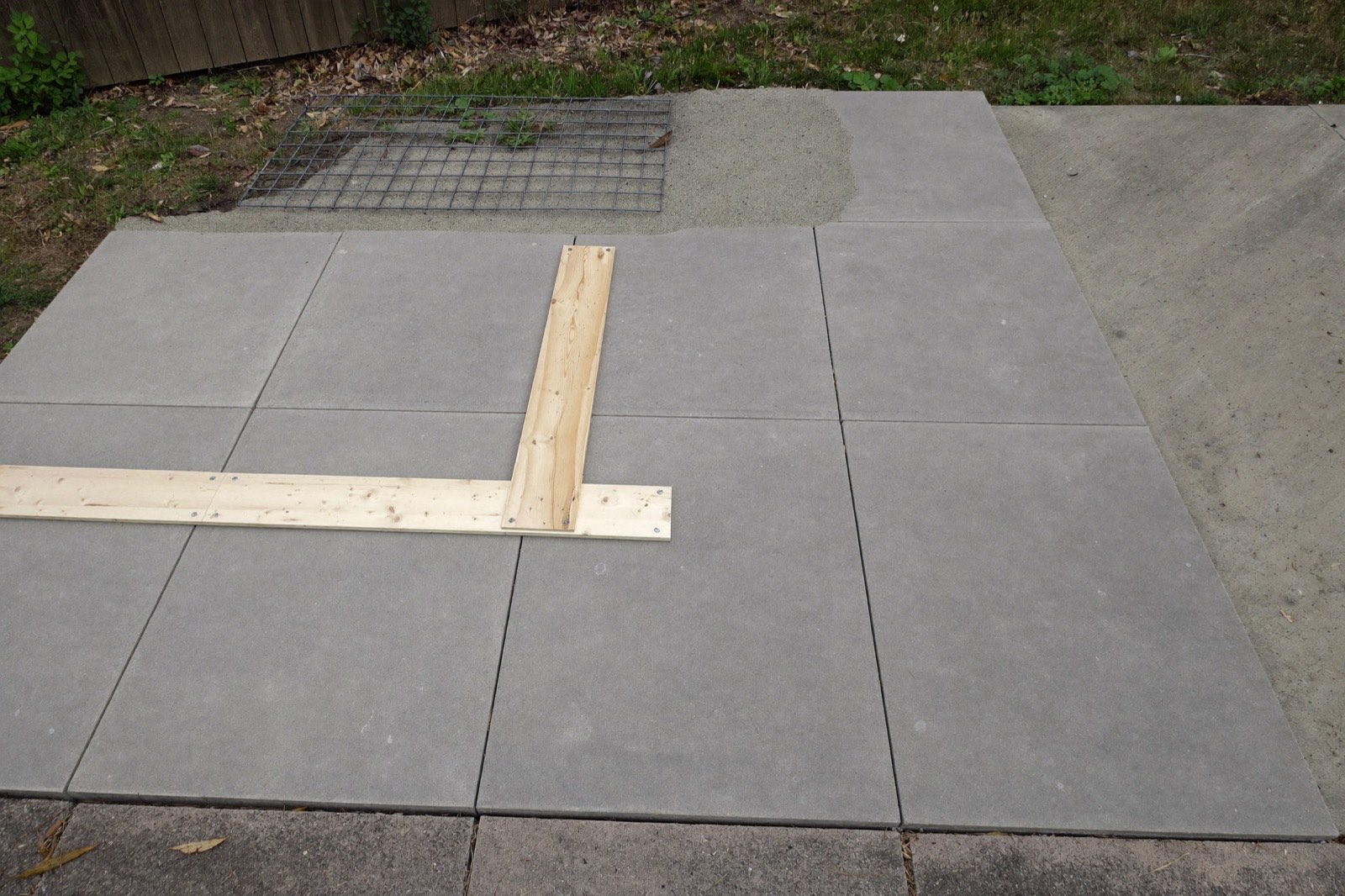 Freshly poured concrete patio slab in wooden forms with a rebar grid — the full assembly a concrete slab cost calculator prices