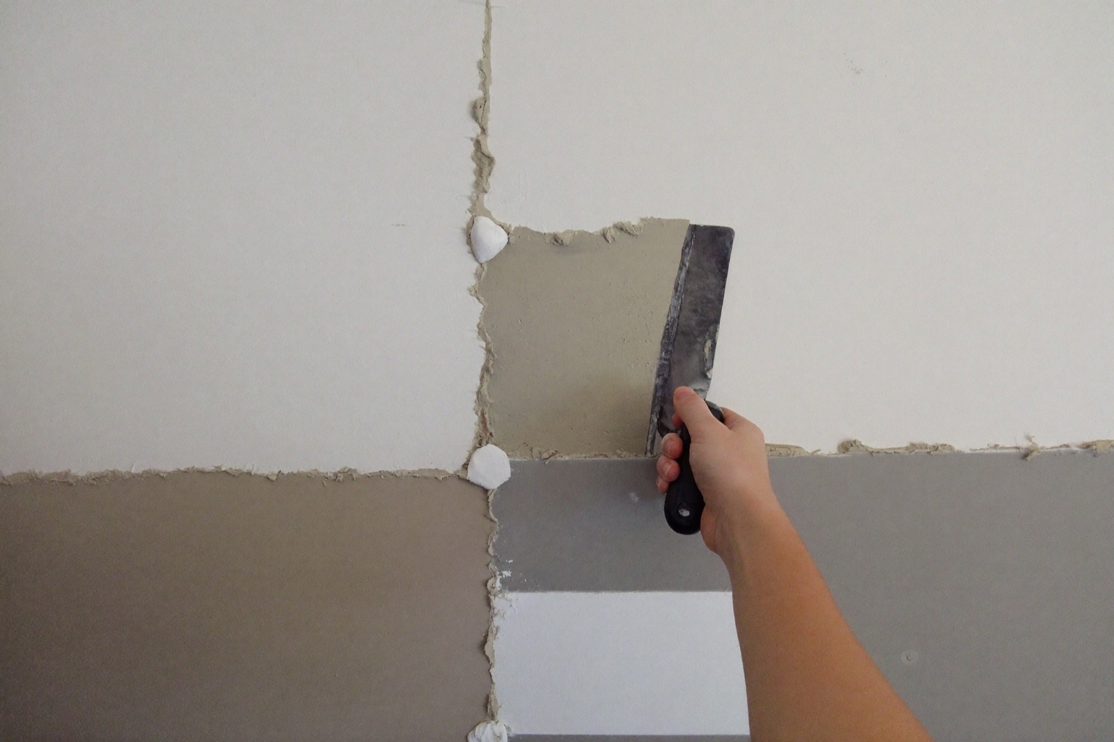 Taping and mudding drywall joints with a finishing knife — joint compound, tape and screws estimated per 1,000 sq ft