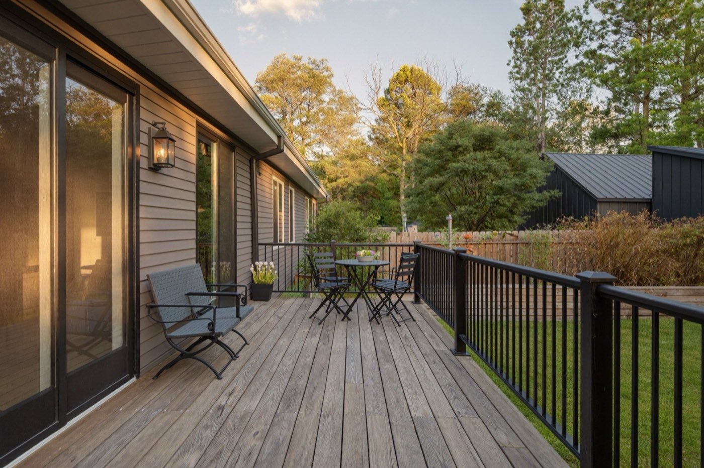 Finished composite backyard deck with black metal railing — installed deck cost estimated by assembly
